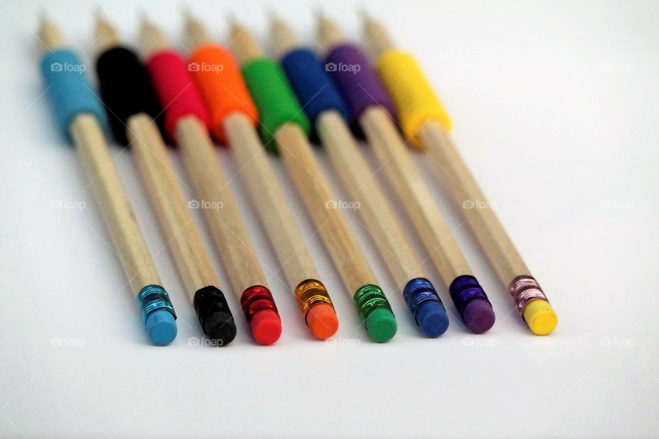 Pencils colorful erasers on white paper sheet 