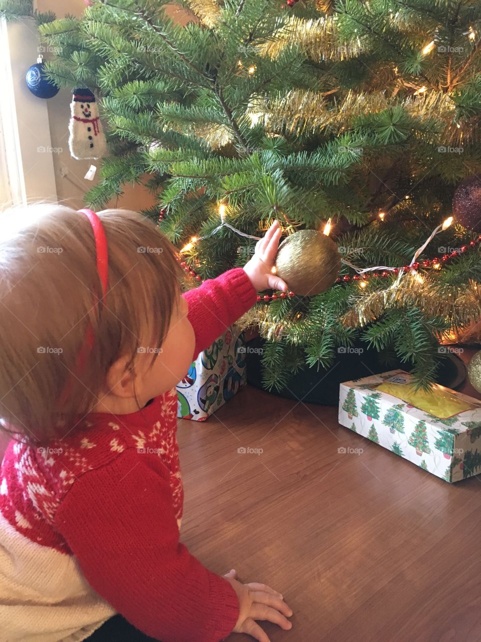 Baby reaching for a ornament 