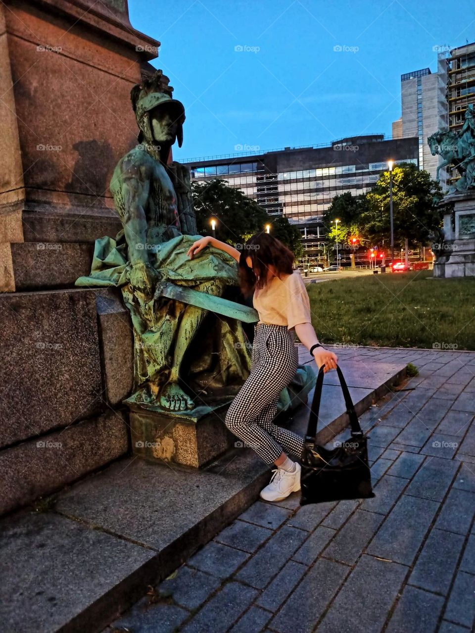 А funny photo of a woman getting impaled by a statue's sword while being surprised by it