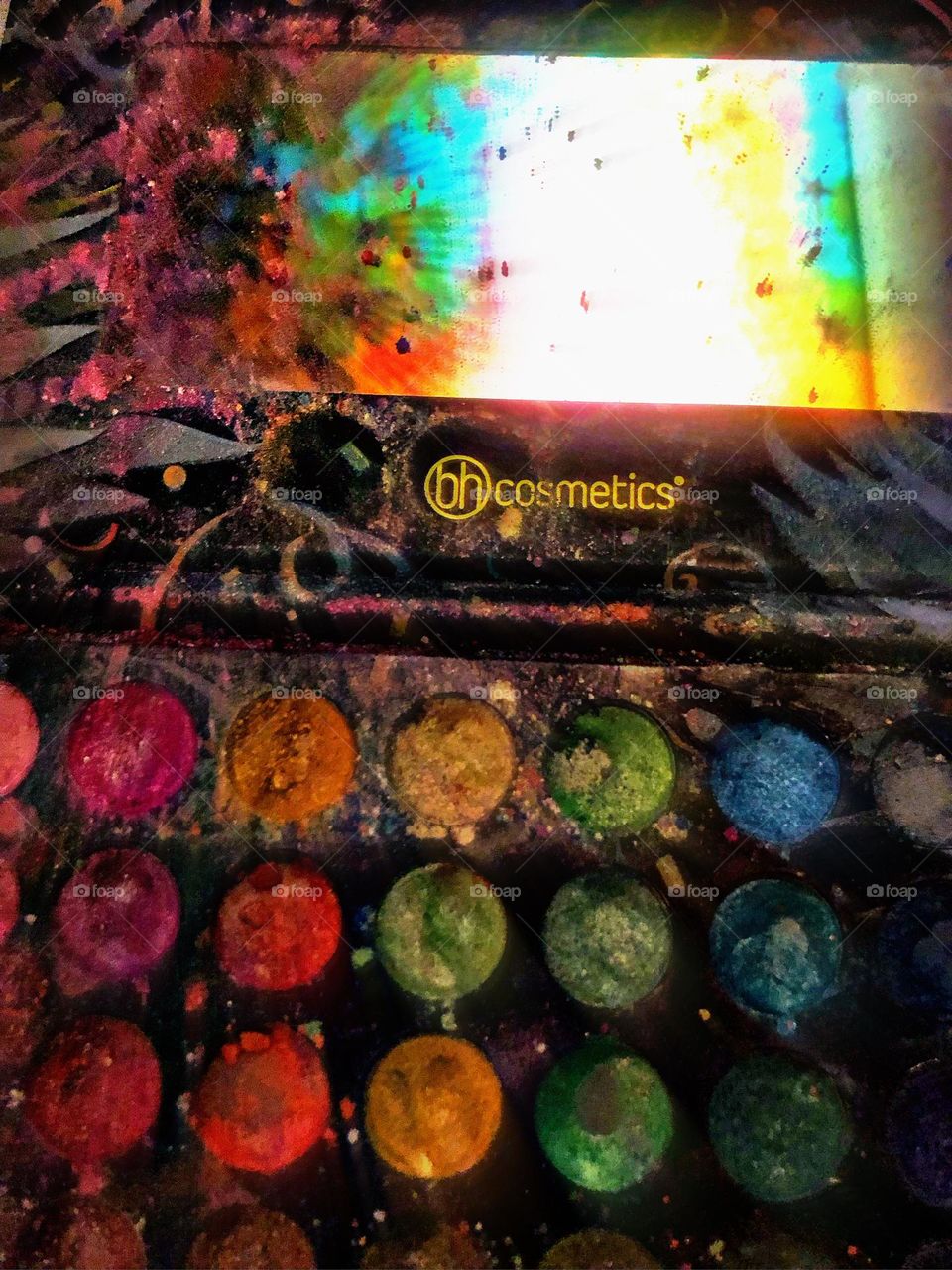 Bh cosmetics makeup palette with a rainbow tapestry in it's reflection