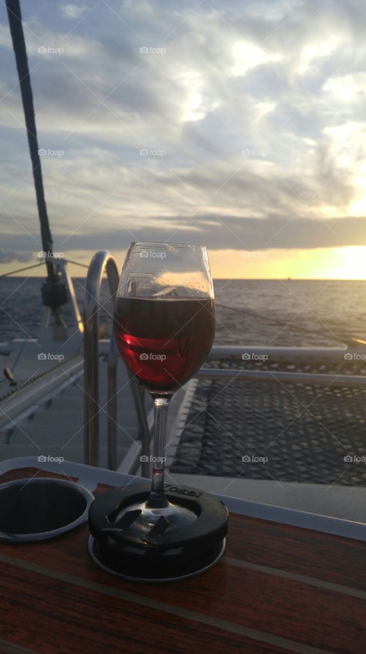 a glass of wine at sunset on a sailboat