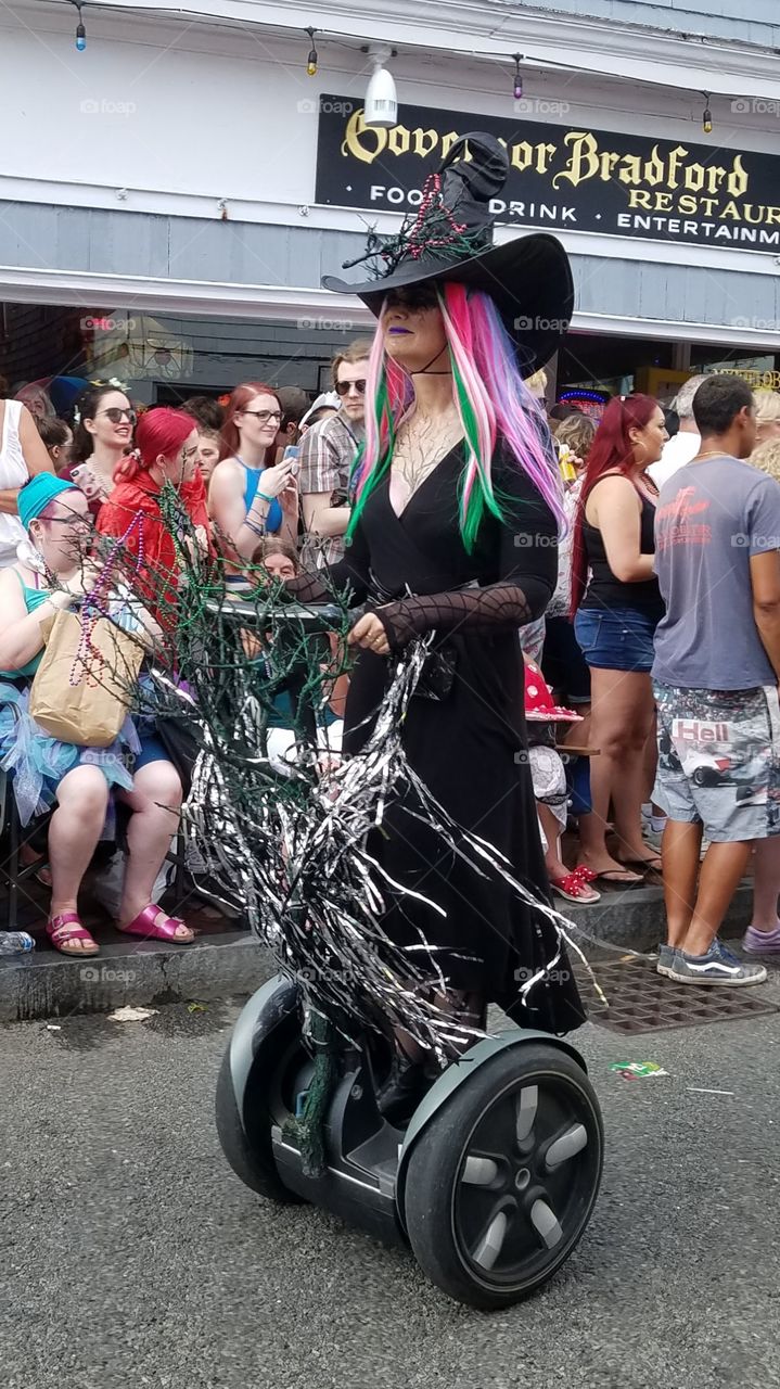 Segway scooter decorated with streamers, with a witch driving on it in a Parade!