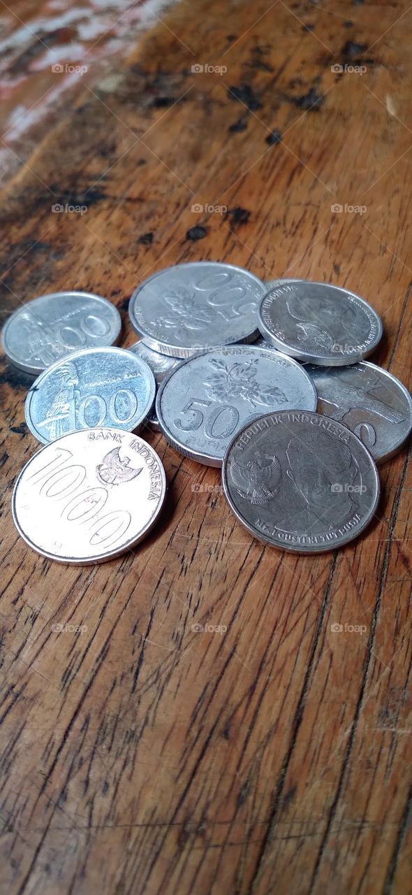 Rupiah coins on an ancient wooden table