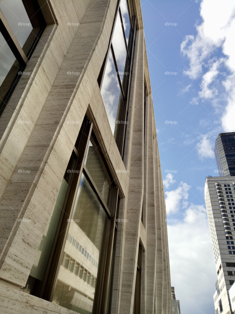 Building in the city. Beauty of Geometry. Sky blue and clouds. Daytime. Sunny day. 