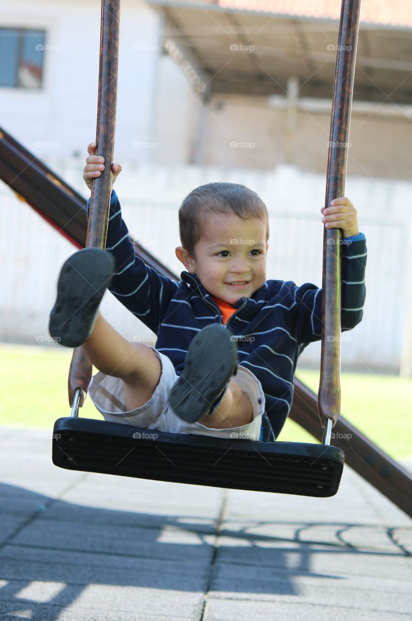 Toddler having fun on a swing