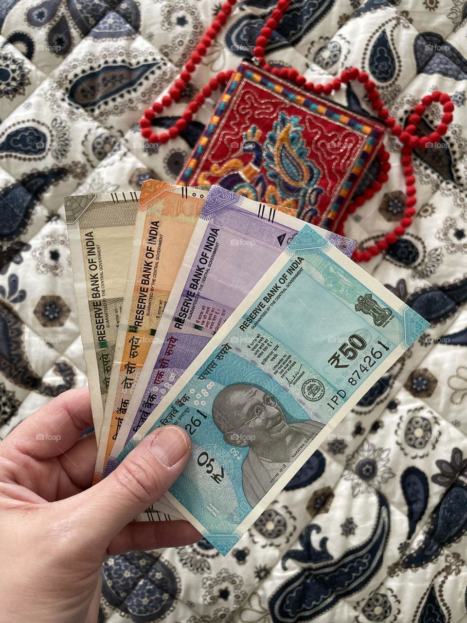 Woman’s hand holding rupees, woman holding money, counting money in India, holding onto rupees in India, paper currency in India, colorful money of the world