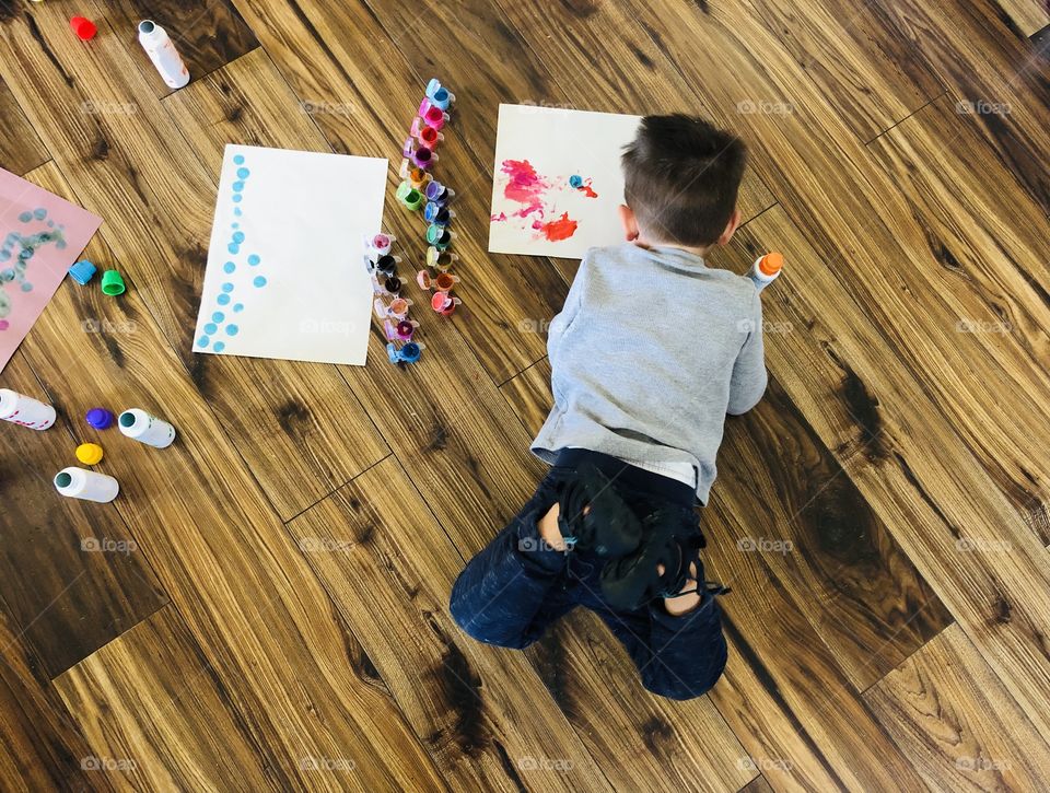 Child on floor with paints