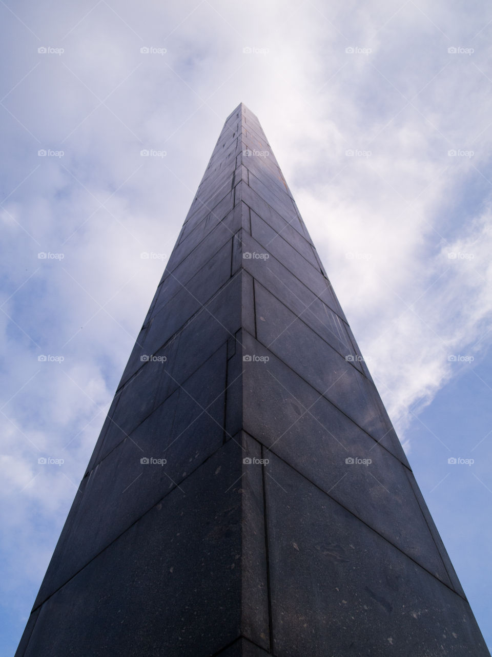 gray concrete cone-shaped monument under a blue sky with white clouds 3