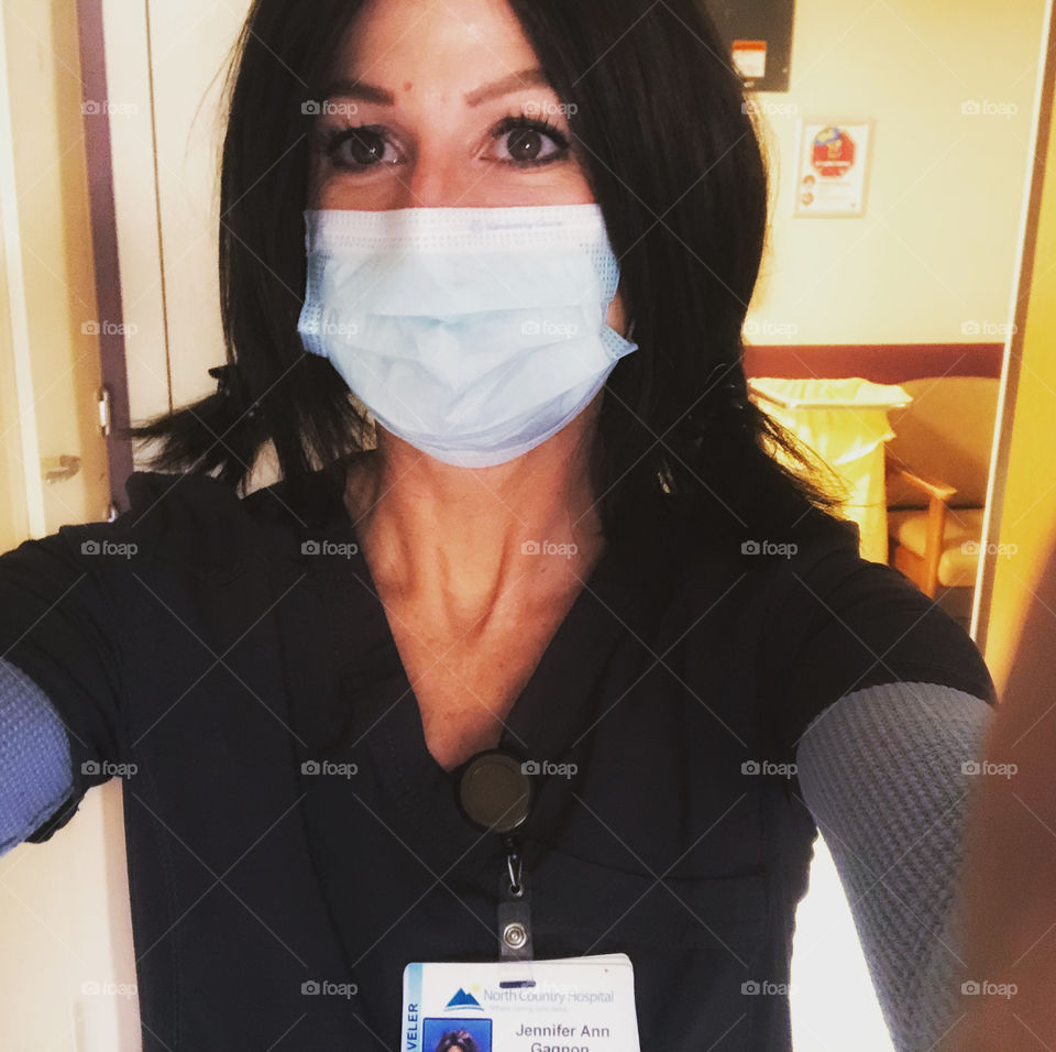 Nurse taking a selfie while at the hospital wearing a surgical mask 