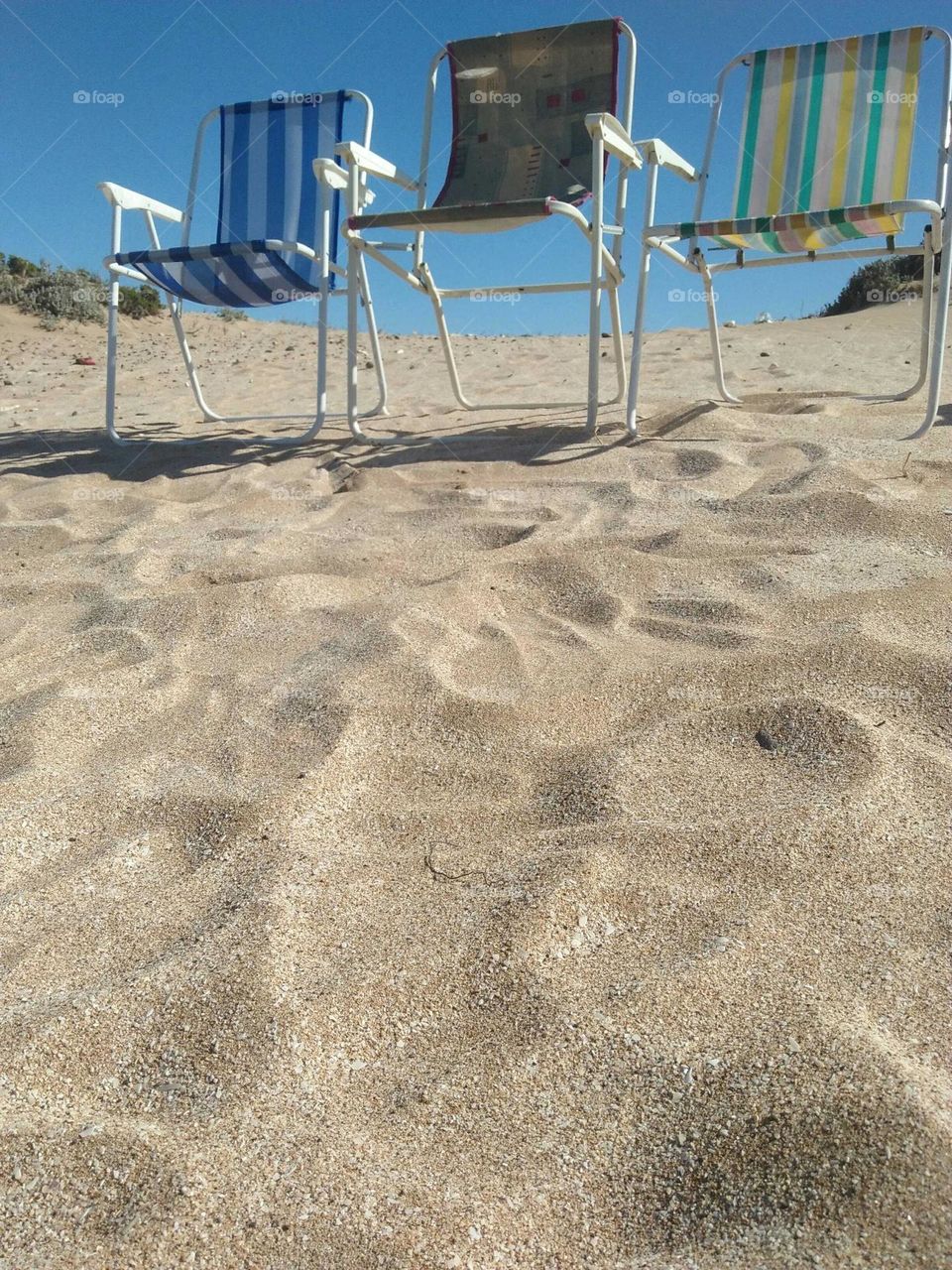 Multicolor chairs on sand at essaouira beach in Morocco.