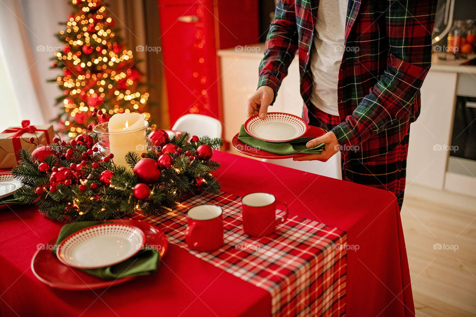 man sets a beautiful decorated winter table for a festive dinner.  Merry Christmas and Happy New Year.