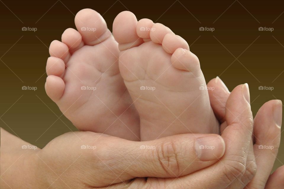 Baby feet held by mom