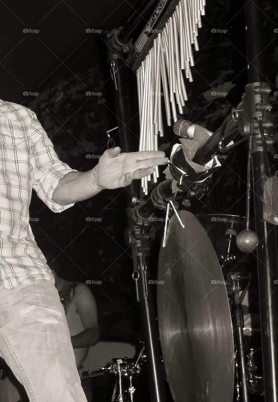 A man playing chimes and cymbal in b&w