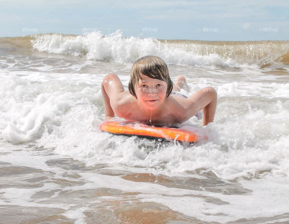 Small boy enjoying on surfboard