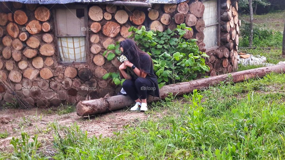 girl is sitting on a log in the village