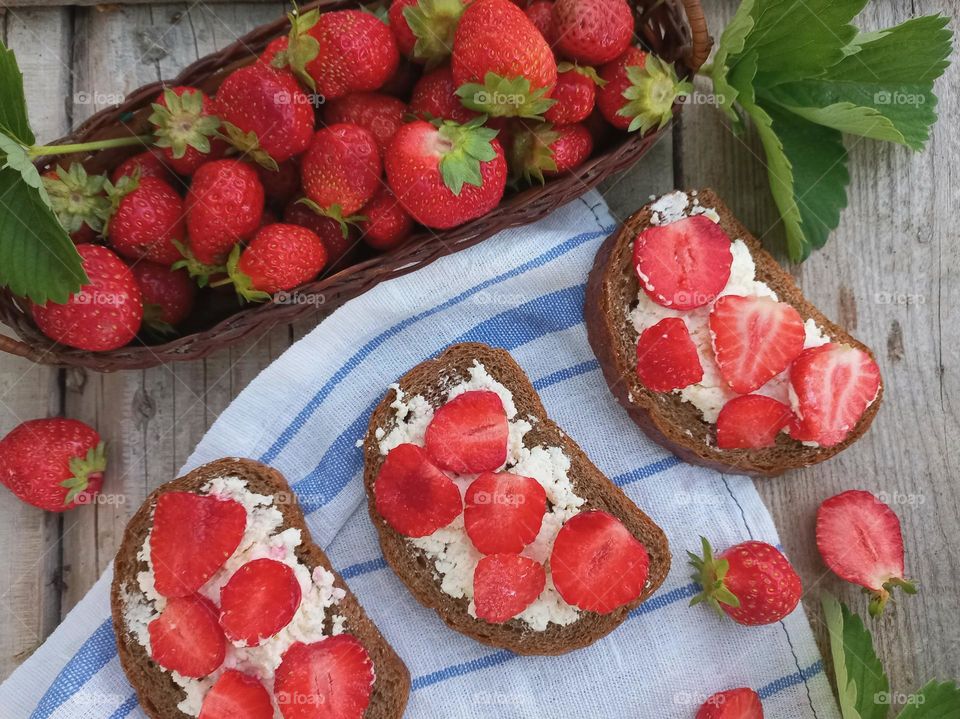 fresh strawberries in a basket and a strawberry sandwich.