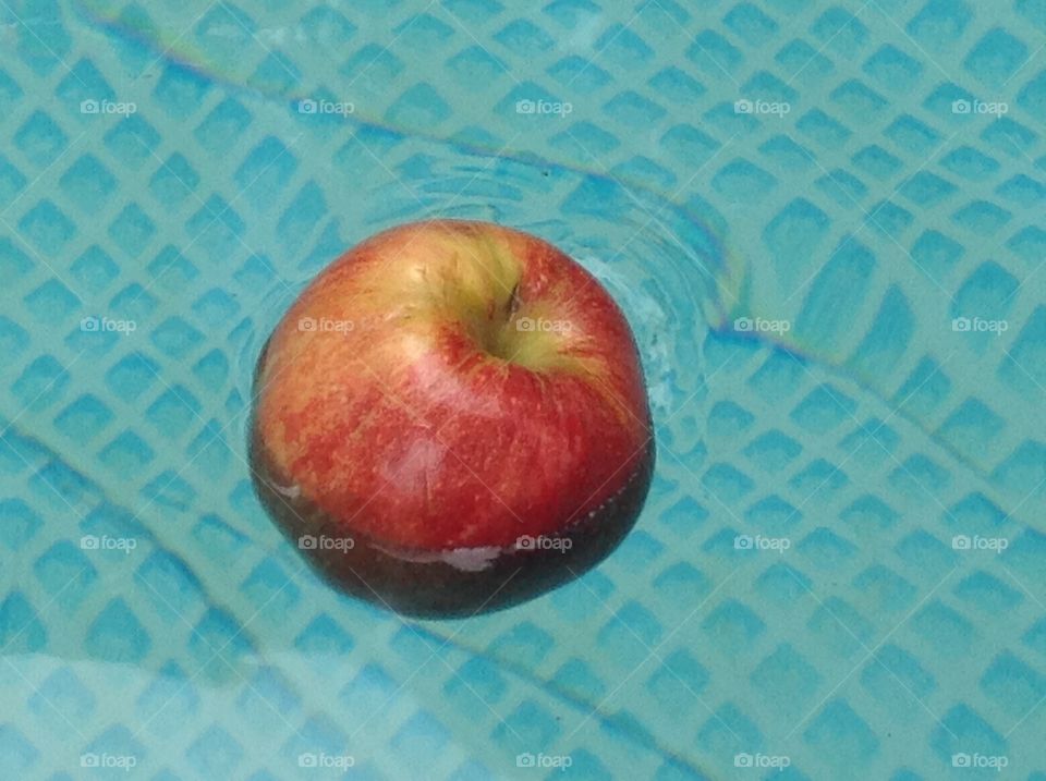 An apple floating in water.