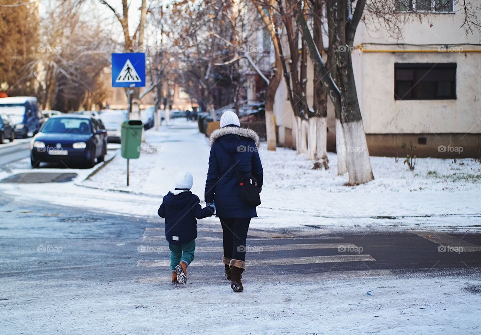 A woman with her child crossing street