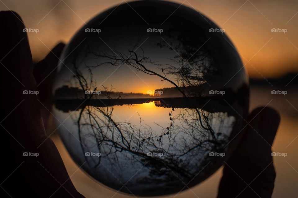 A clear morning golden sunrise at the lake as seen through a lensball. 