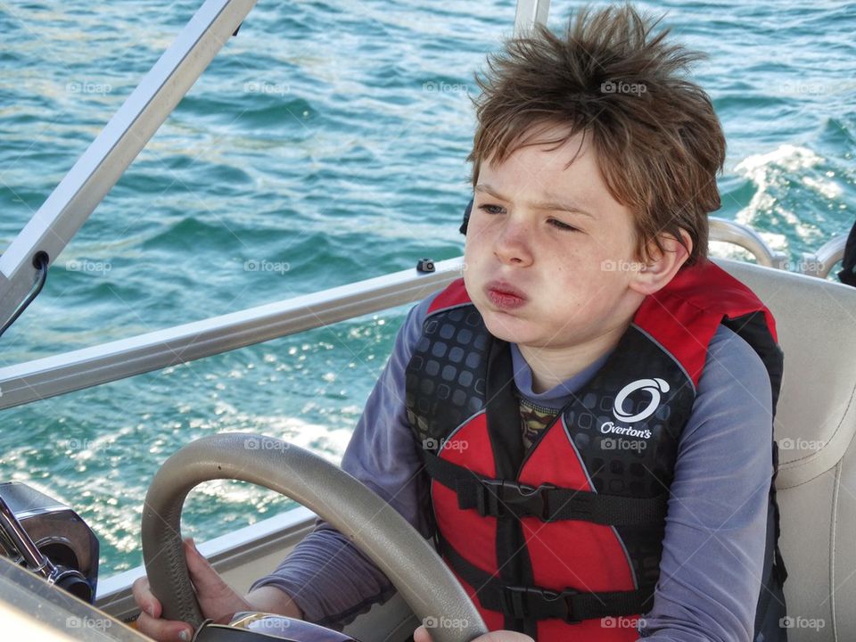 Boy Driving A Boat
