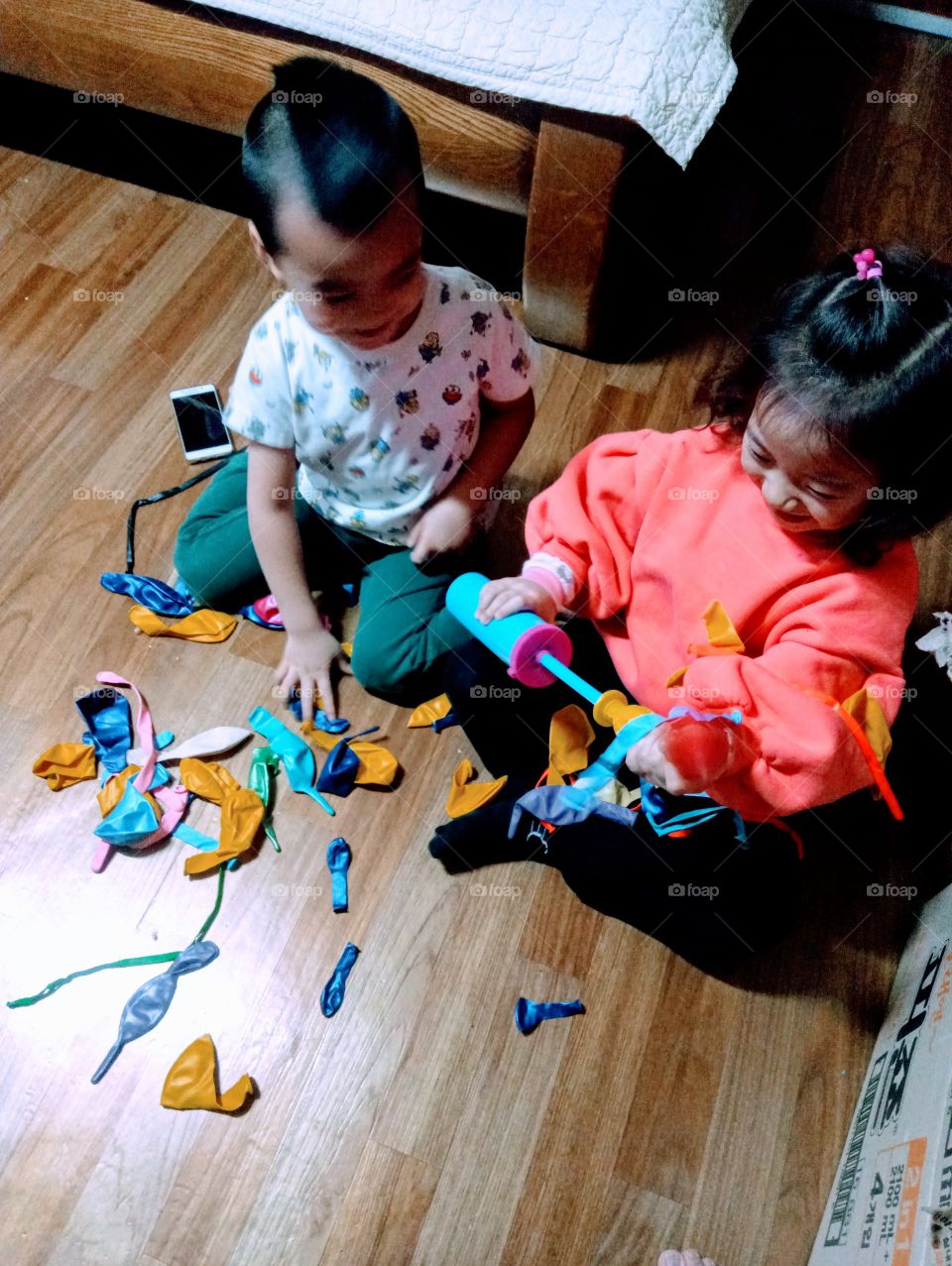 the two kids and the balloons.
the girl visit this home.
there are lots of toys around.
but what makes her happy and what makes the two of them play together is only because of this ""balloons";
they enjoy together with this lovely ballons.