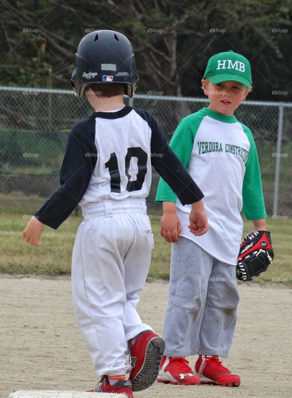 Good Sportsmanship . Two Young Baseball Players From Opposing Teams Shake Hands
