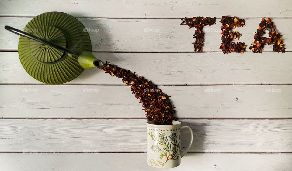 Herbal tea poured from kettle in cup