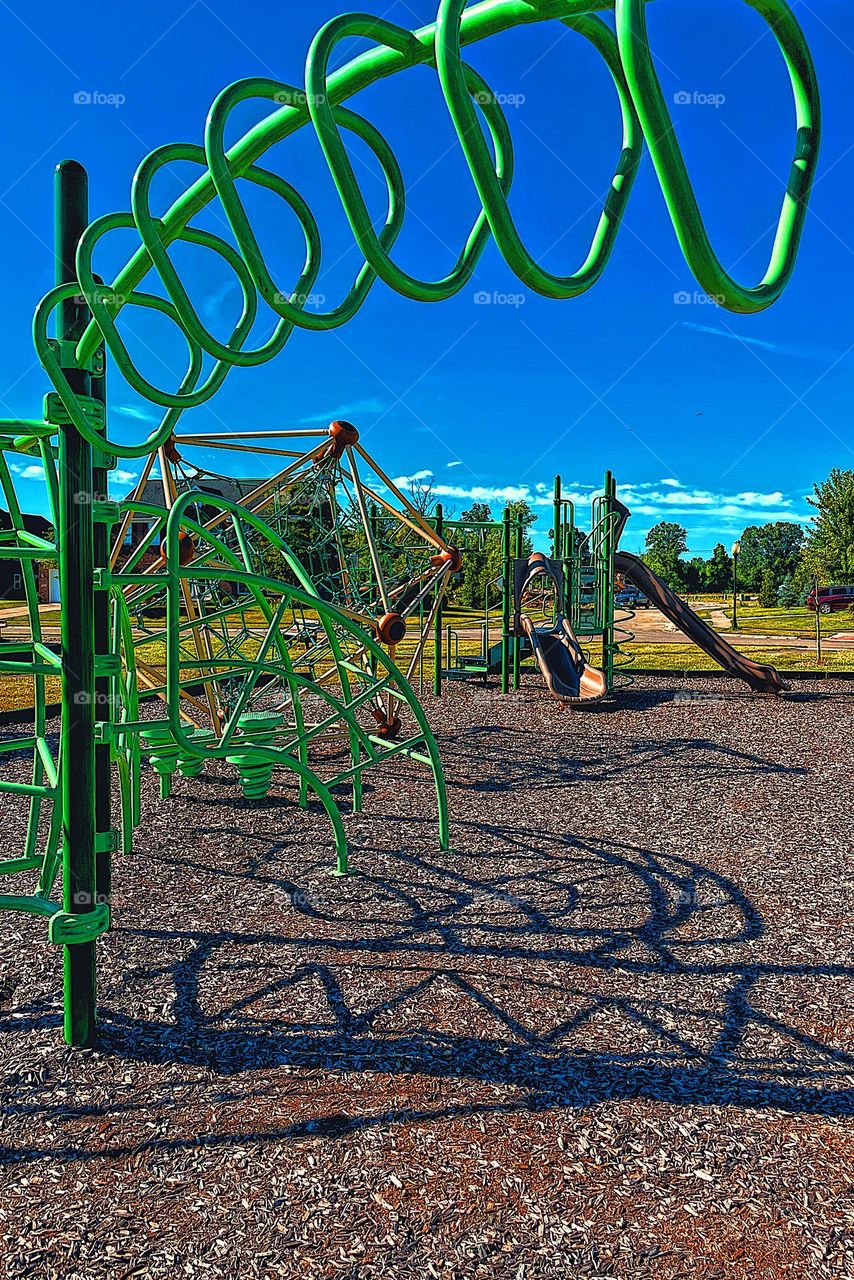 Metal triangular climbing equipment at the park, climbing equipment at the park, playground equipment in the summertime, shadows and metal at the park, fun at the park, fun with kids, playing outdoors