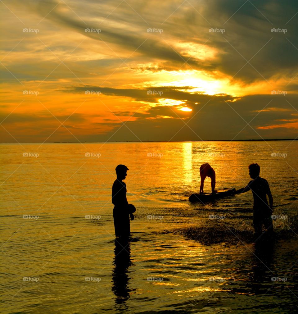 Amazing Silhouettes! Friends enjoying the sunset and having fun! The sun is like a great big romantic, inspirational fire in the sky. Brilliant streaks of yellow, orange, gold, blue, pink and red overcome the blue and purple of the sky. The sky resembled a prism; all the colors blended perfectly together. It's as if the colors and intensity of the light is just right! 