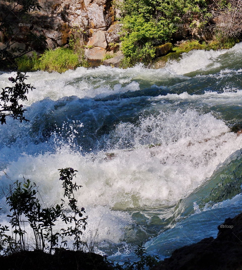 The raging waters of the Deschutes River at Dillon Falls on a sunny summer day 