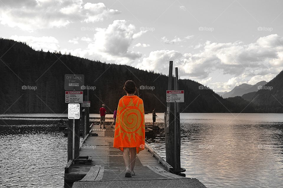 Summer fun at lake. Swimming off the dock Bright orange beach towel 