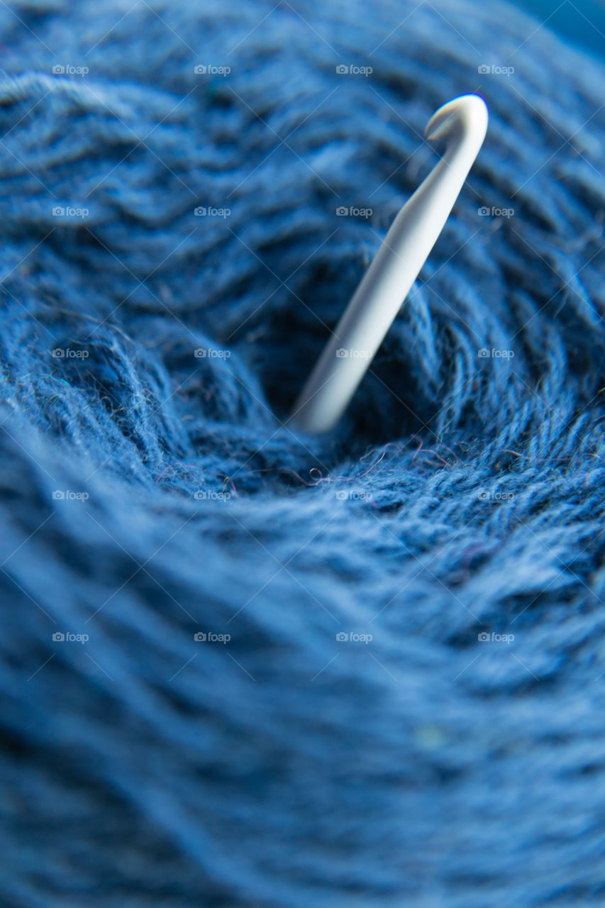 Crochet hook and blue wool