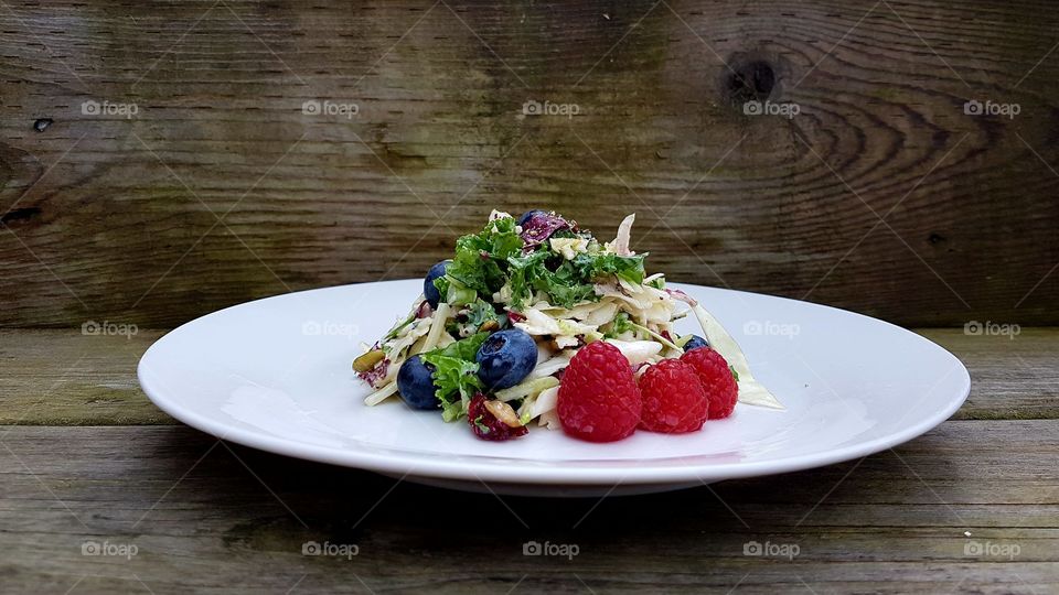 Colourful salad in plate on wooden