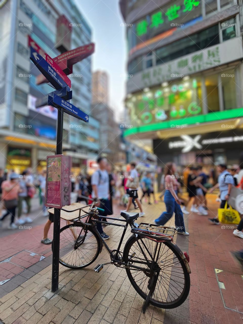 One lonely bicycle parked by the pole on a Hong Kong busy street