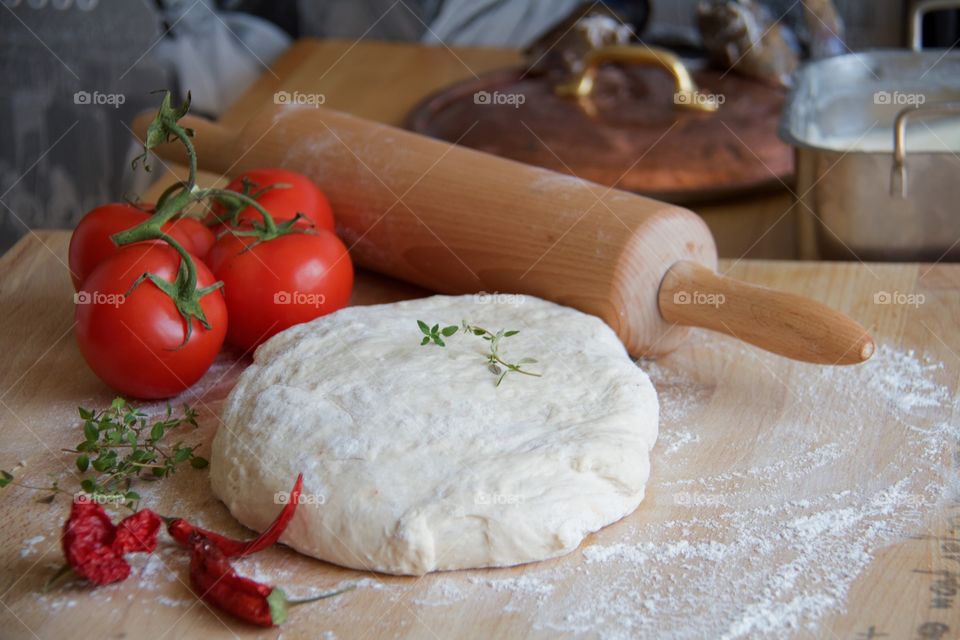 Dough with tomato and rolling pin