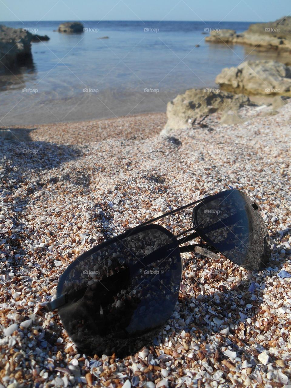 summer travel accessories sunglass on a sea shore