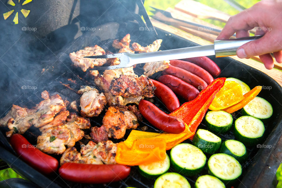 Selection of meat grilling barbecue with spicy sausages and vegetables