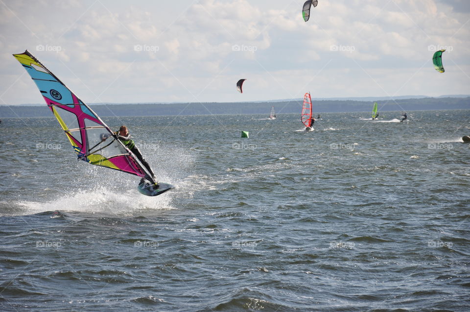 A windsurfer having fun jumping on the water