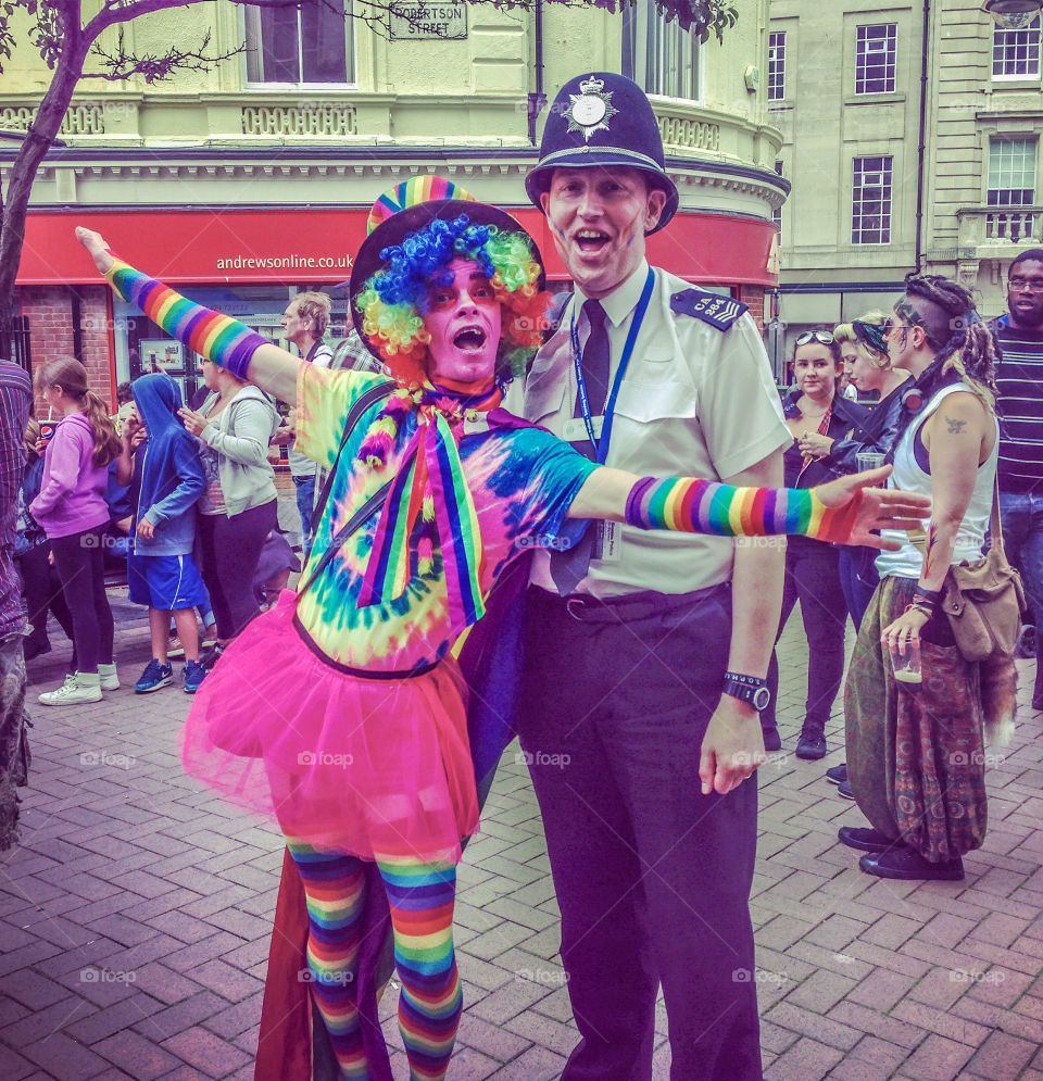 A colourful reveller poses with a police officer at Hastings Pride 2016