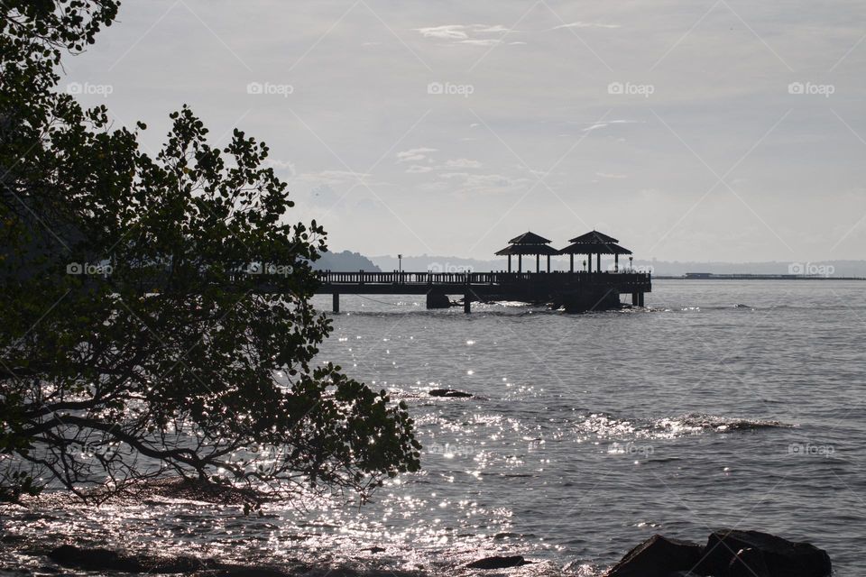 Jetty on Pulau Ubin island in Singapore with light sparkles on the water.