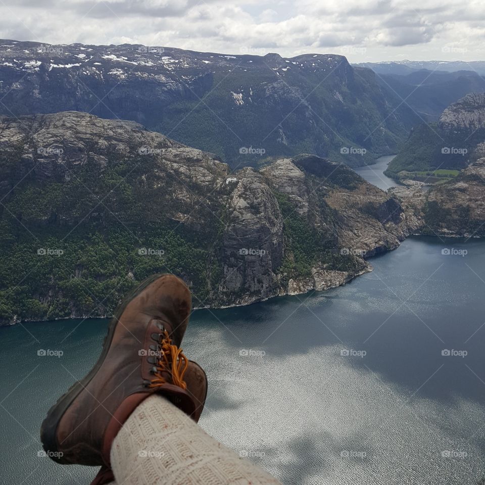 scuffed hiking boots overhanging a fjord in Norway. Preikestolen or Pulpits rock