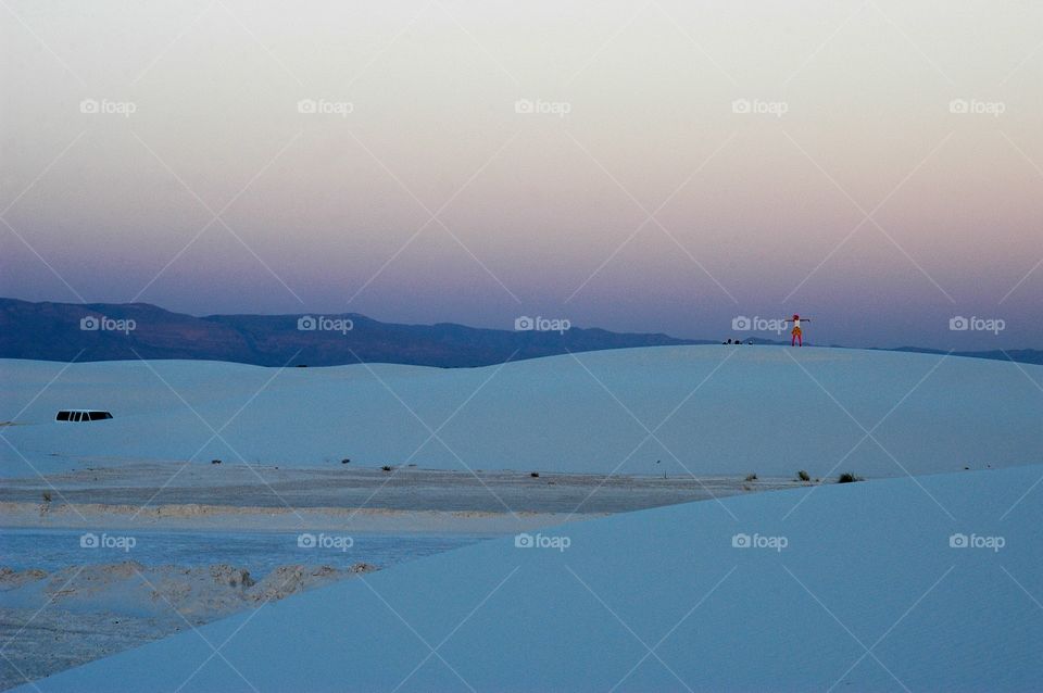 Person on dune at dusk at white sands New Mexico park 