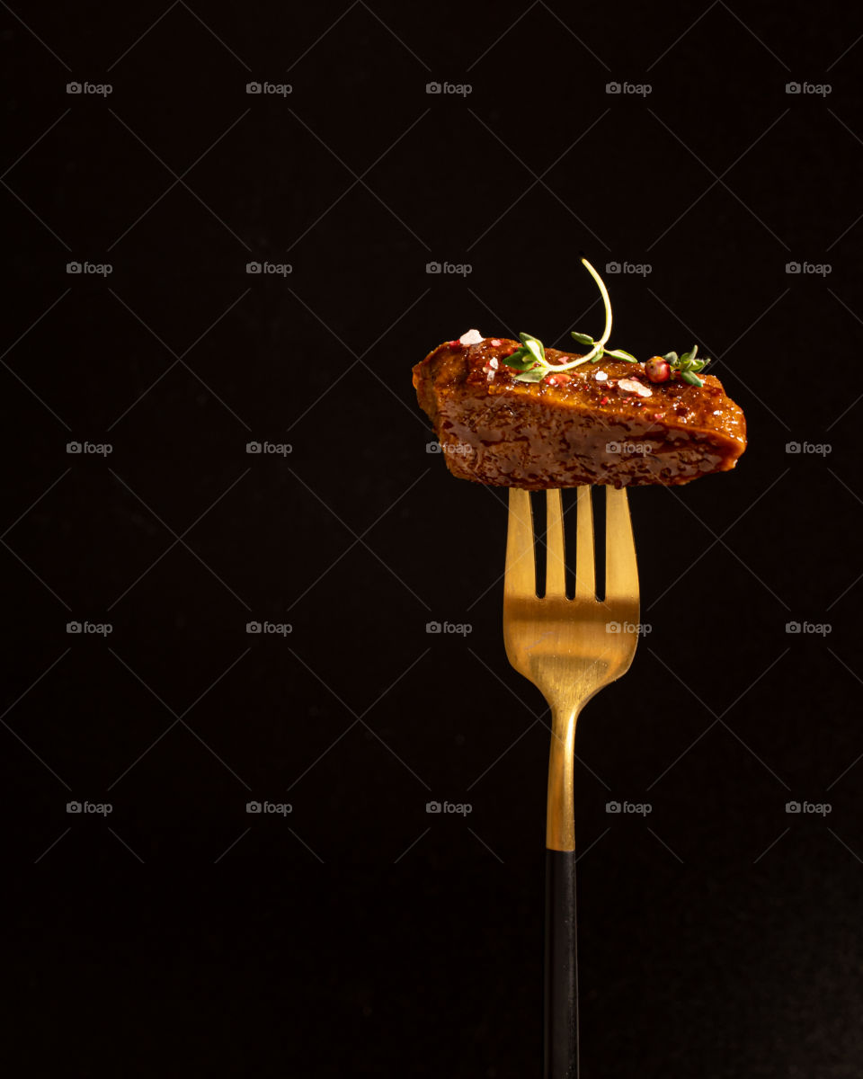 A piece of vegan steak on a gold fork