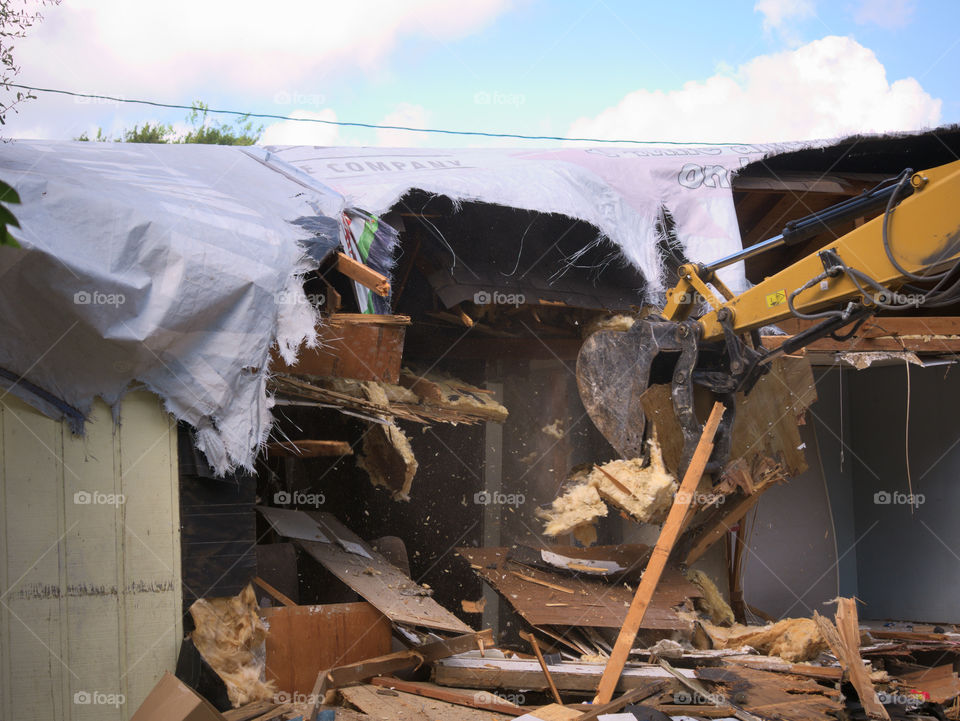 Excavator Removing Insulation and Lumber while Demolishing a Hurricane Harvey Storm Damaged Home