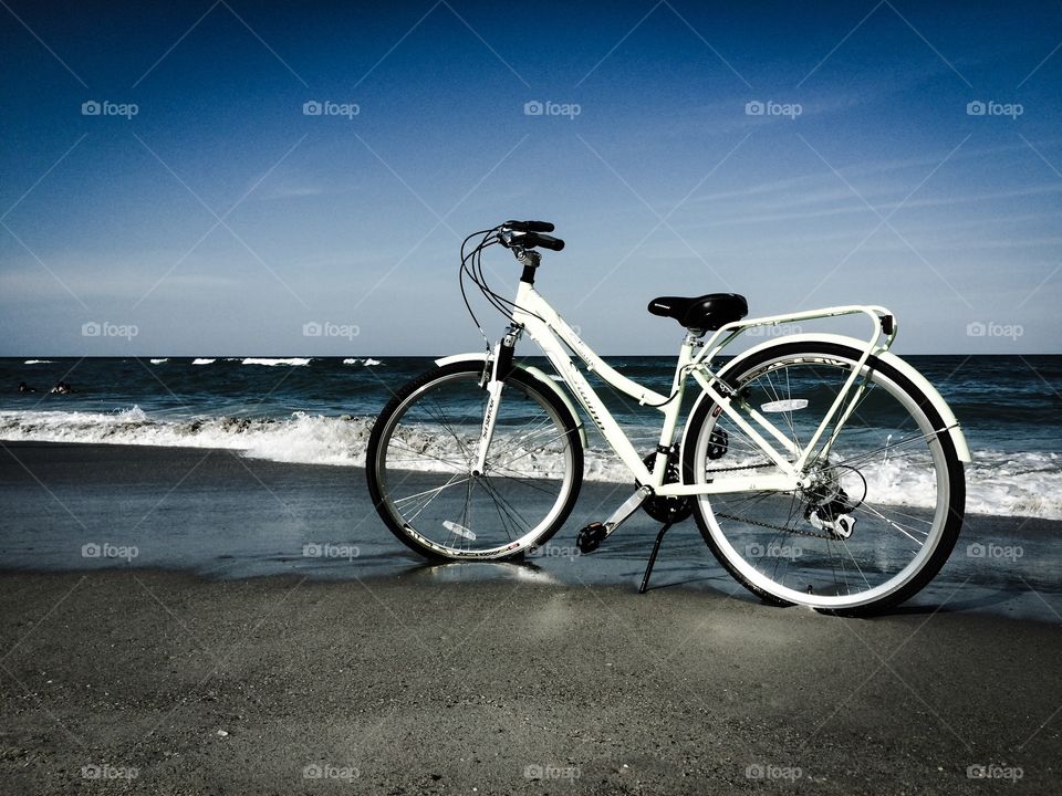 Bike at Beach. The surf rolls in and the bike takes in the view after a long ride in the wet sand. 