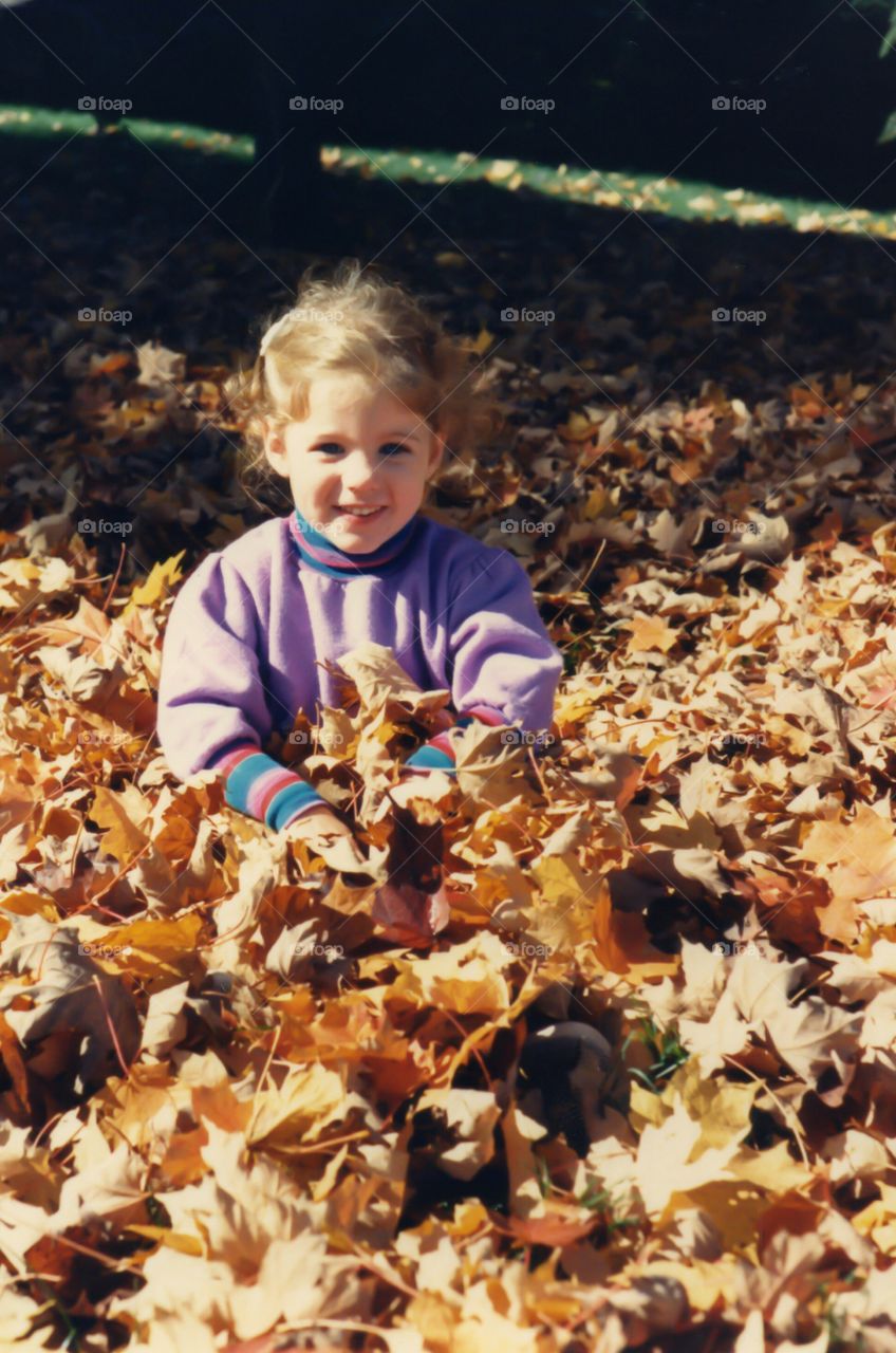 Close-up of a girl in autumn leaves