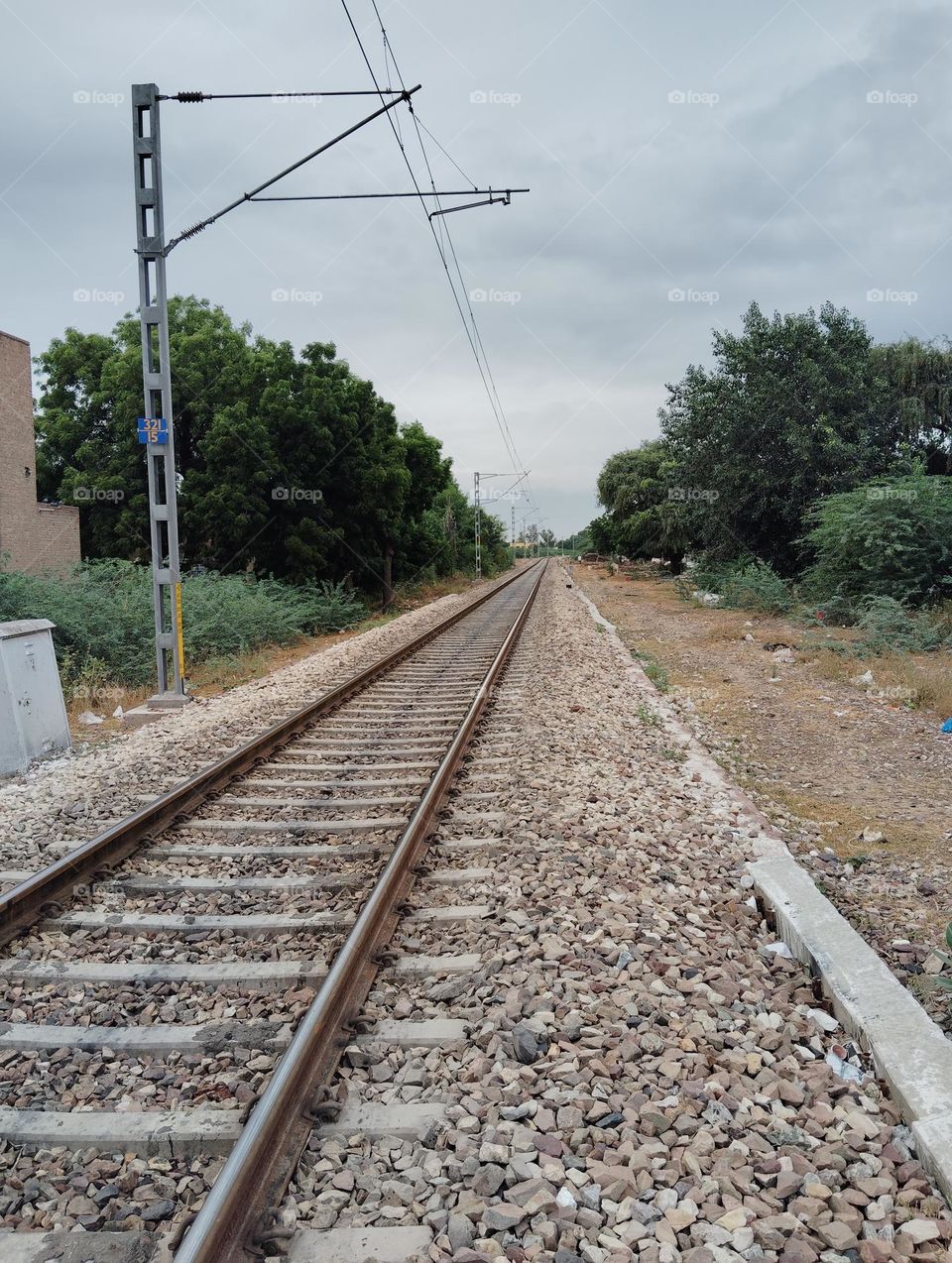 the way, railway track, sleeper, transport vehicles move on the track, clouds, green trees both of side