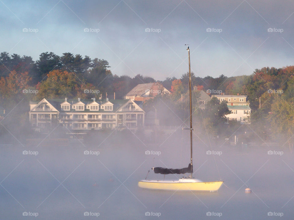 A serene fall morning on the lake with sailboat