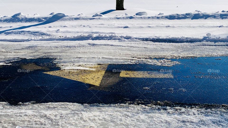 A fast food driveway has a faded yellow arrow to tell drivers where to go. 