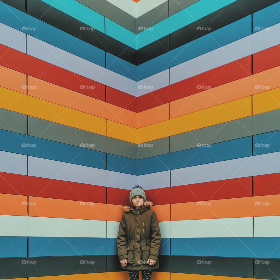 Woman standing in front of multi colored background